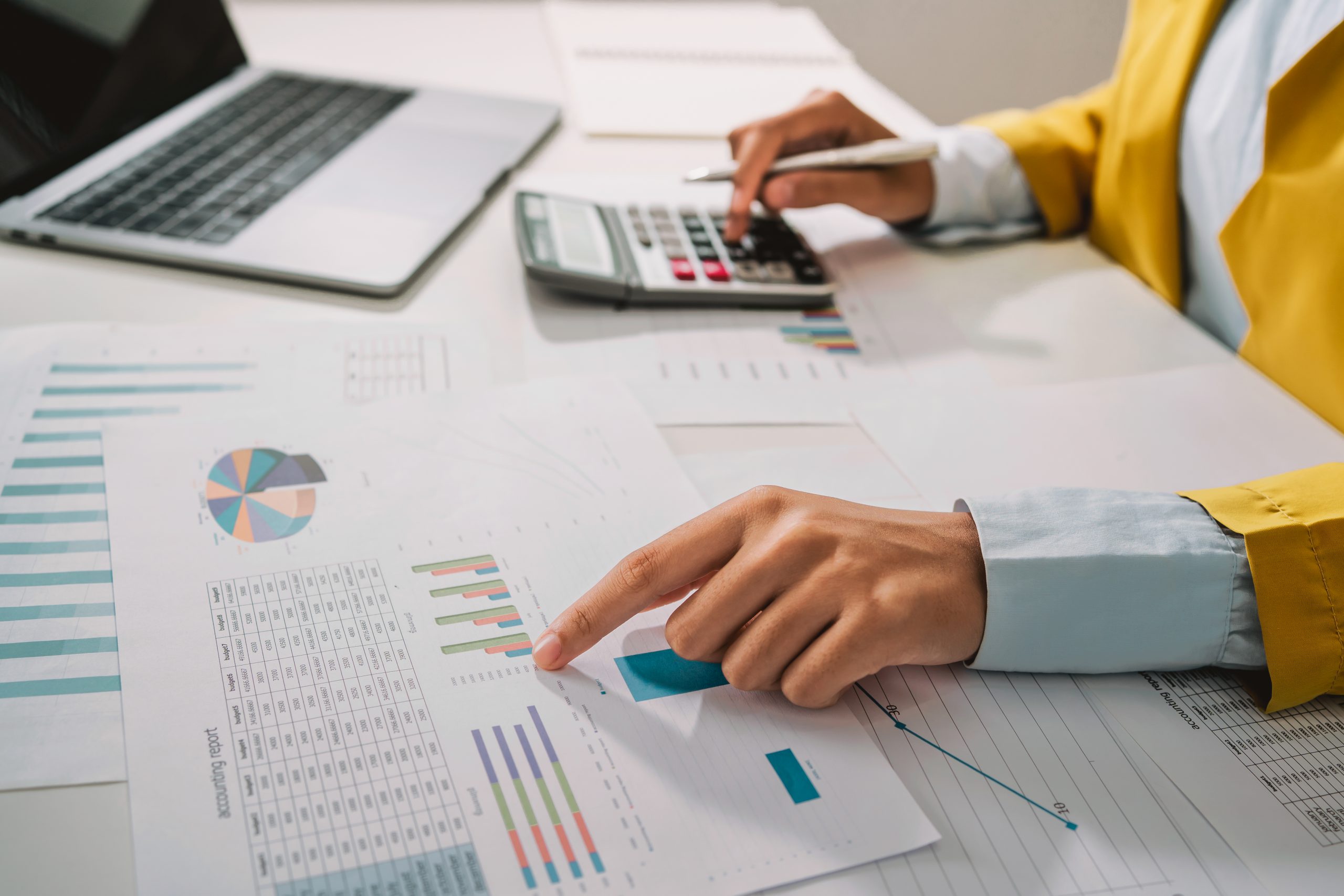 Woman accountant use calculator and computer with holding pen on